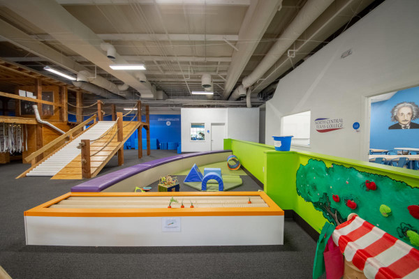 Summer activity in Denton. A large, vibrant indoor children's play and learning museum featuring an interactive soft play area, a wooden bridge structures.